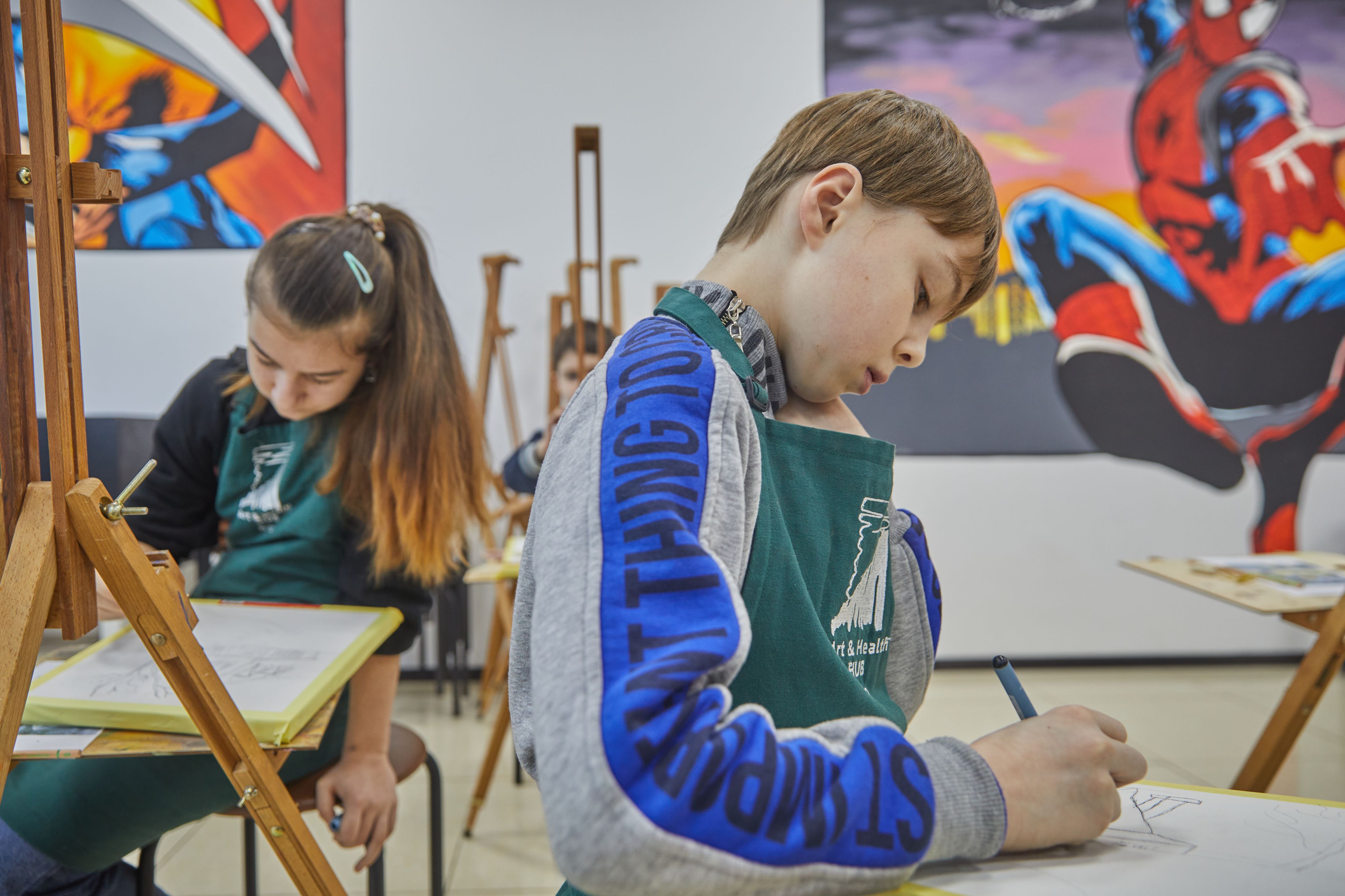 Anton*, 12 anni, e Iryna*, 11 anni, disegnano la sagoma di una casa durante un laboratorio di arteterapia a Poltava, Ucraina.