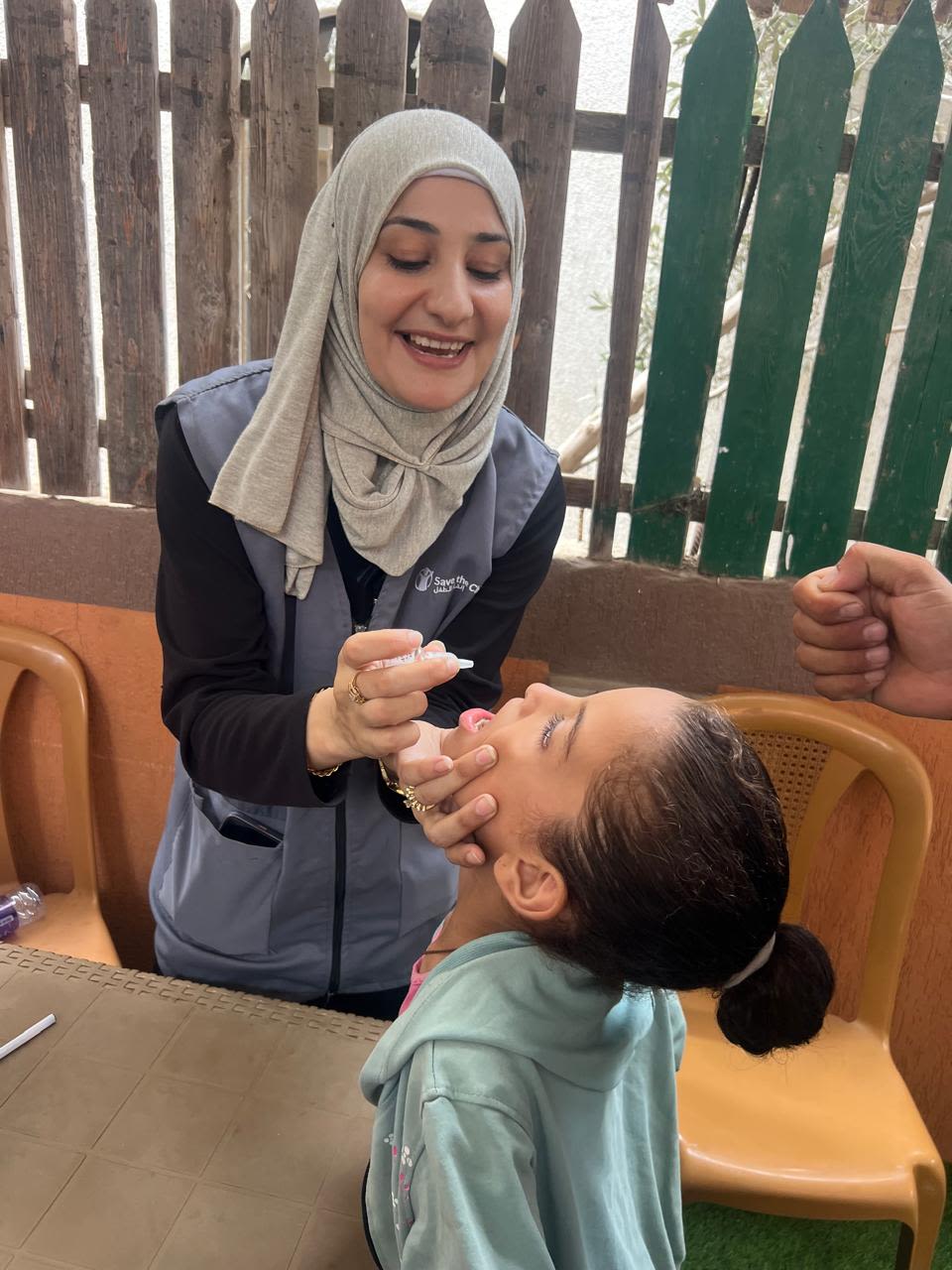 Operatrice Save the Children somministra medicina ad una bambina a Gaza