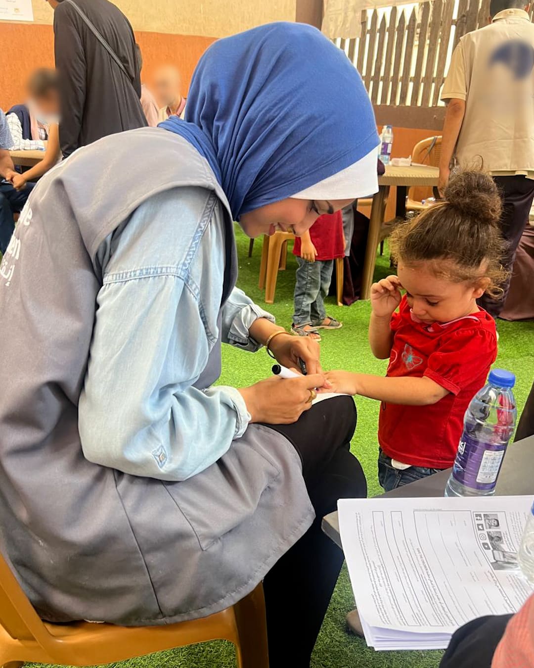 Operatrice umaniataria Save the Children cura una bambina a Gaza